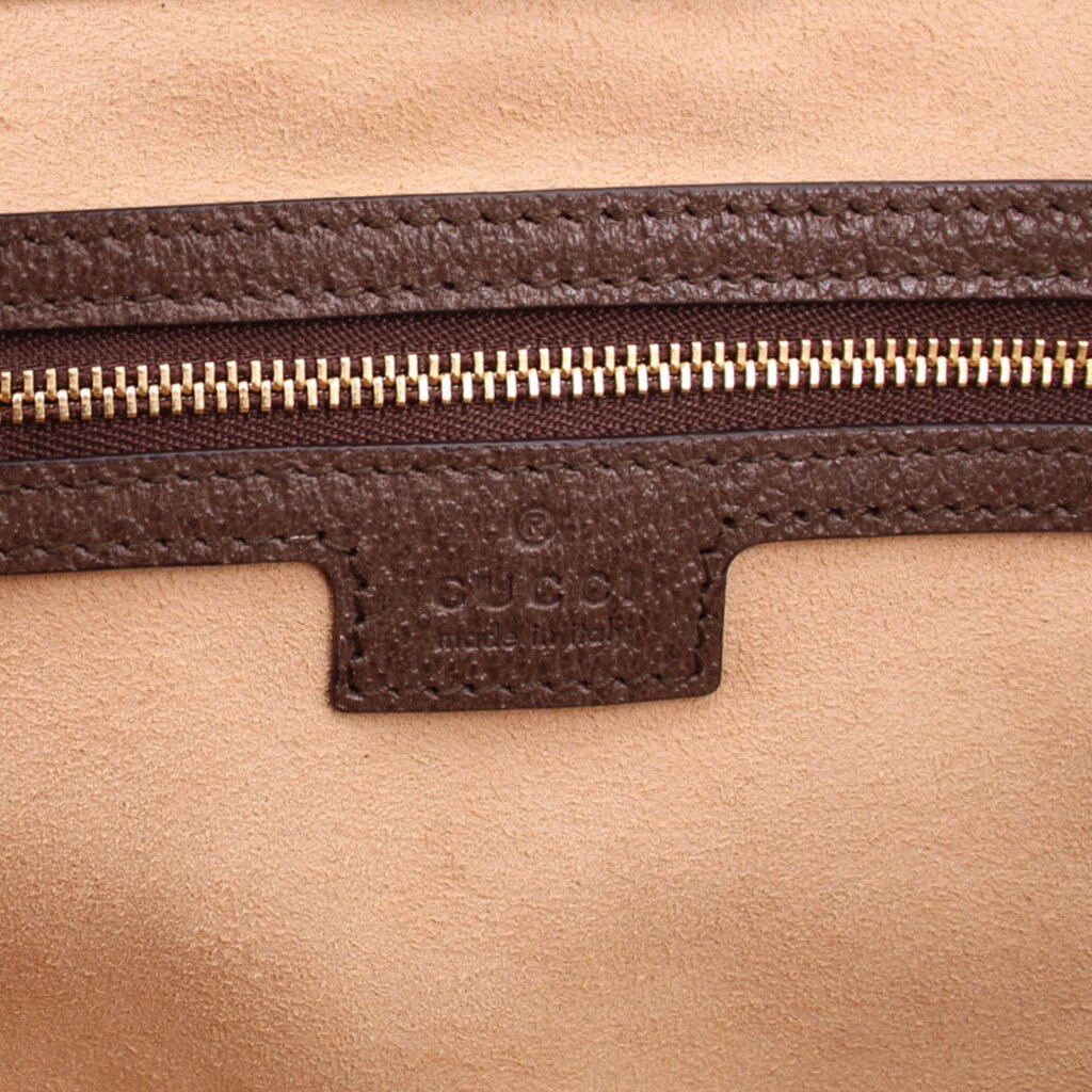 Tote bag close-up of brown zipper tape and leather trim with Gucci label