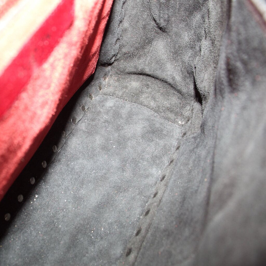 Red fabric lining with stitched seam inside black quilted bag