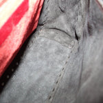 Red fabric lining with stitched seam inside black quilted bag