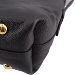 Close-up of black leather shoulder bag with gold-tone snap button and curved seam