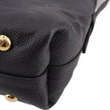 Close-up of black leather shoulder bag with gold-tone snap button and curved seam