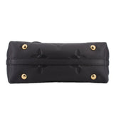 Black monogram top handle bag with gold-tone snap hardware and stitched trim