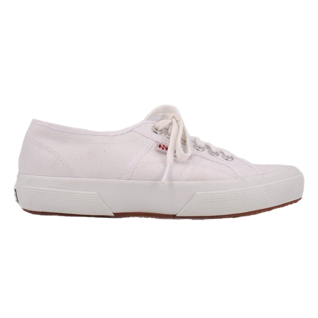 White lace-up sneakers with low-profile canvas panels and white rubber sole