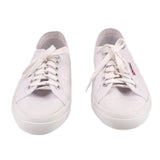 White sneakers pair, front view with eyelet laces and textured rubber toe cap