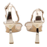 Gold metallic heeled sandals, back view: ankle strap and rhinestone trim