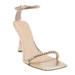 Metallic gold heeled sandal with rhinestone strap and open toe, ankle strap