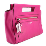 Magenta Coach clutch bag with wrist strap, front zipper pocket, and hanging tag