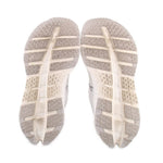 White sneaker outsoles with patterned tread and ON logo on heel area