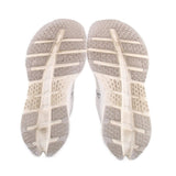 White sneaker outsoles with patterned tread and ON logo on heel area