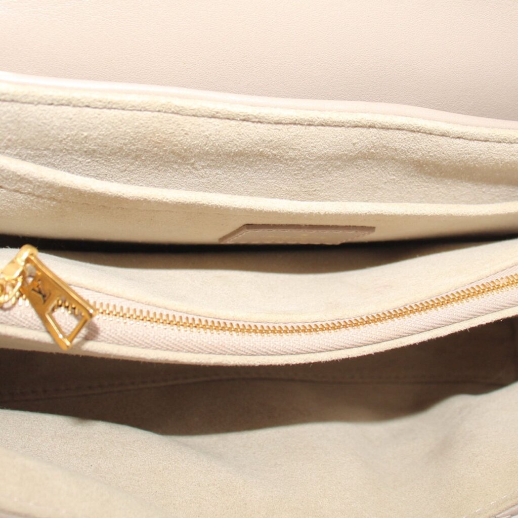 Taupe interior of shoulder bag with zipper track and gold zipper pull