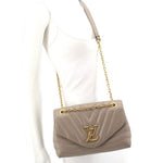 Taupe quilted mini shoulder bag worn crossbody with gold chain strap and logo flap