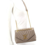 Taupe quilted mini shoulder bag worn crossbody with gold chain strap and logo flap