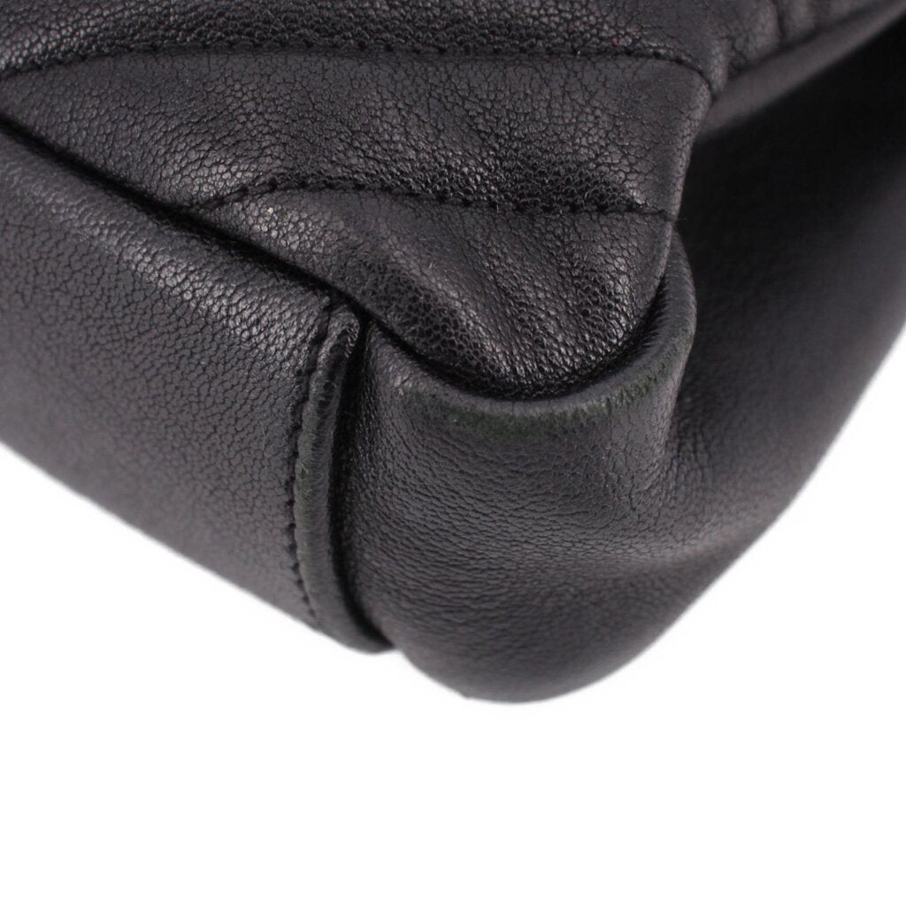 SAINT LAURENT black leather crossbody bag close-up with stitched quilted panel