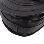 Black saddle crossbody bag close-up of seam details and flap edge hardware