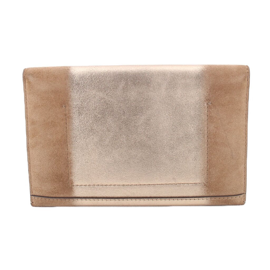 Tan foldover clutch with back panel seam and folded flap.