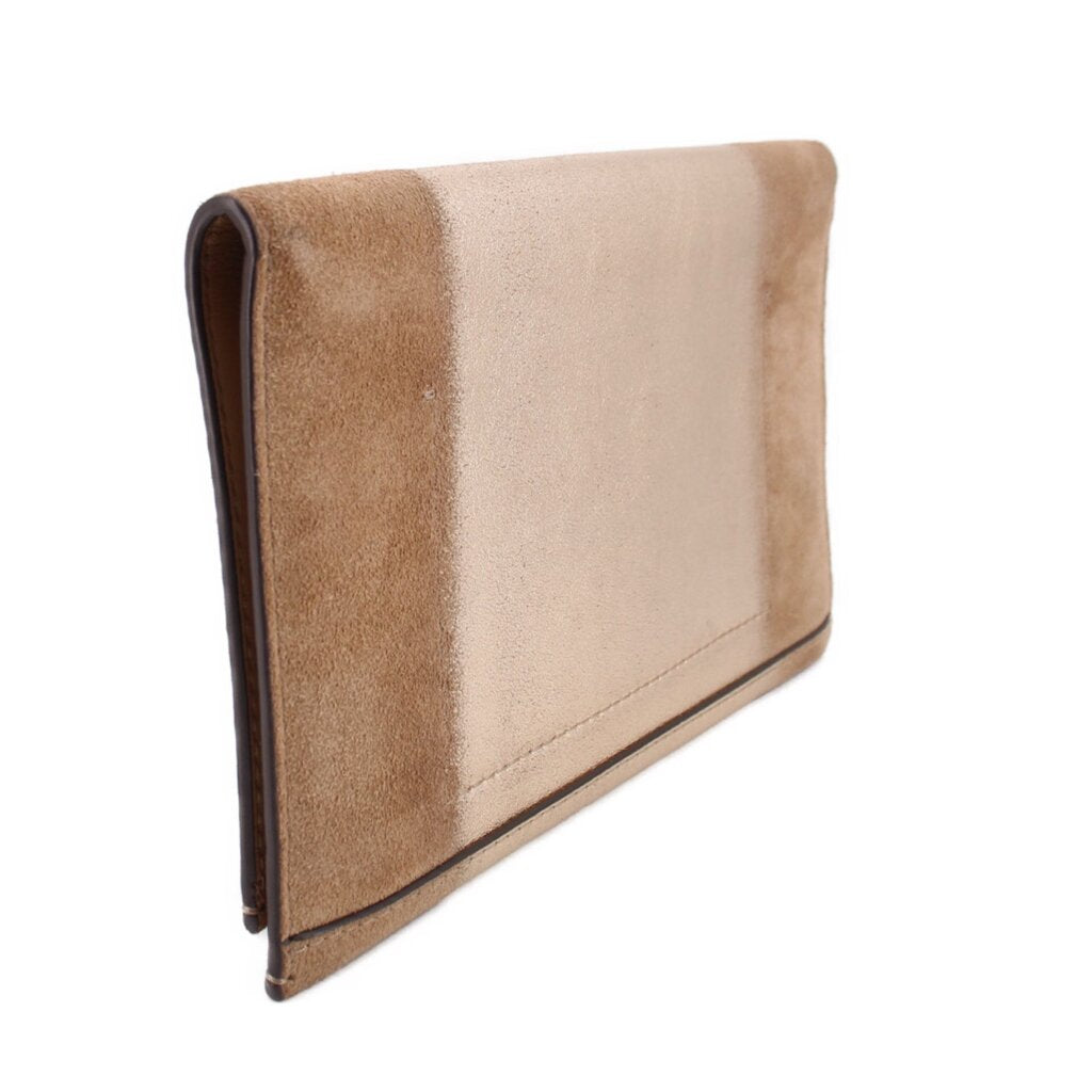 Tan foldover clutch with curved flap and dark edge trim.