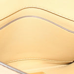 Tan foldover clutch interior lining with stitched edge and frame.