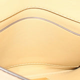 Tan foldover clutch interior lining with stitched edge and frame.
