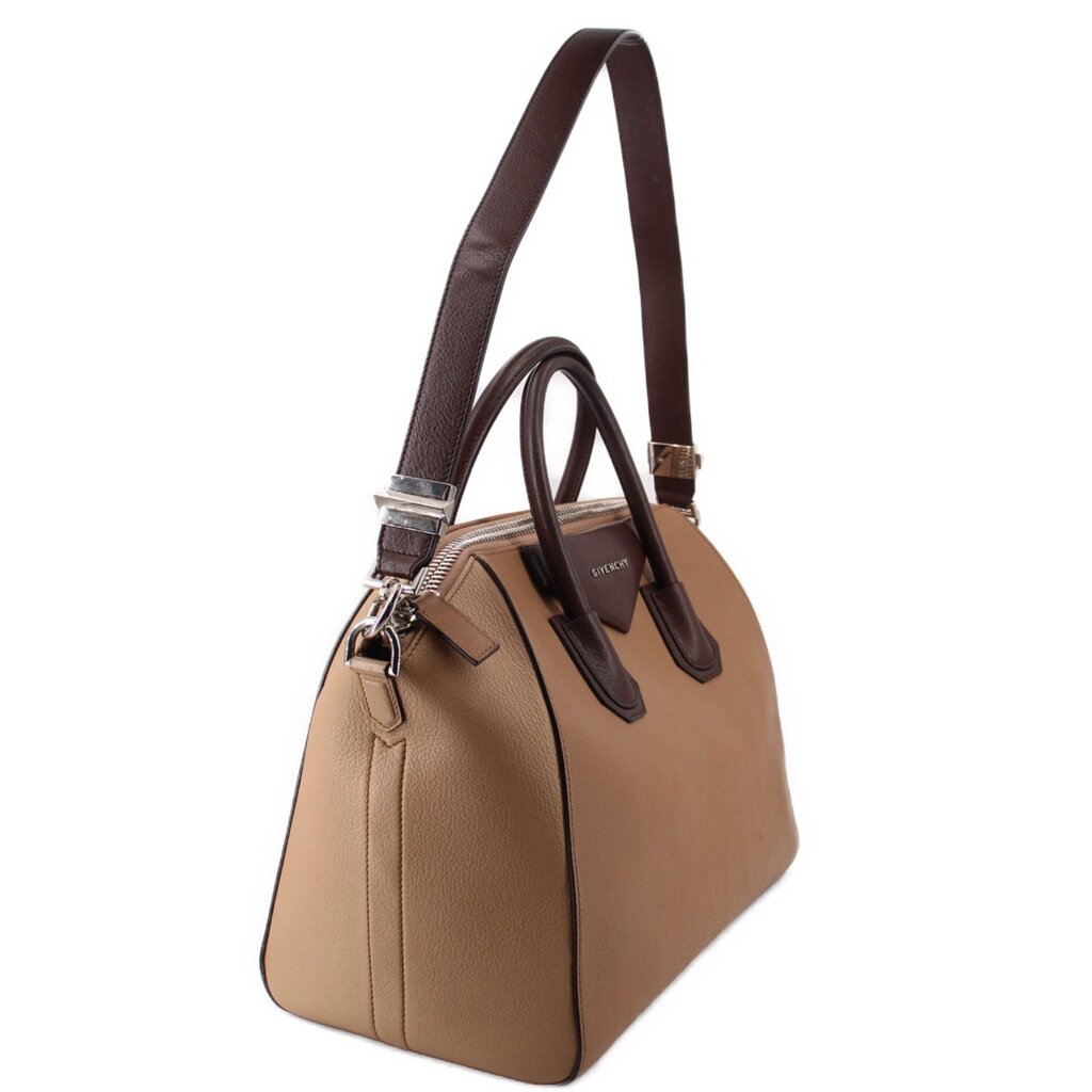 Brown leather tote bag with dual top handles, shoulder strap, and side details