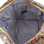 Gray fabric-lined interior of floral tote bag with small brand patch
