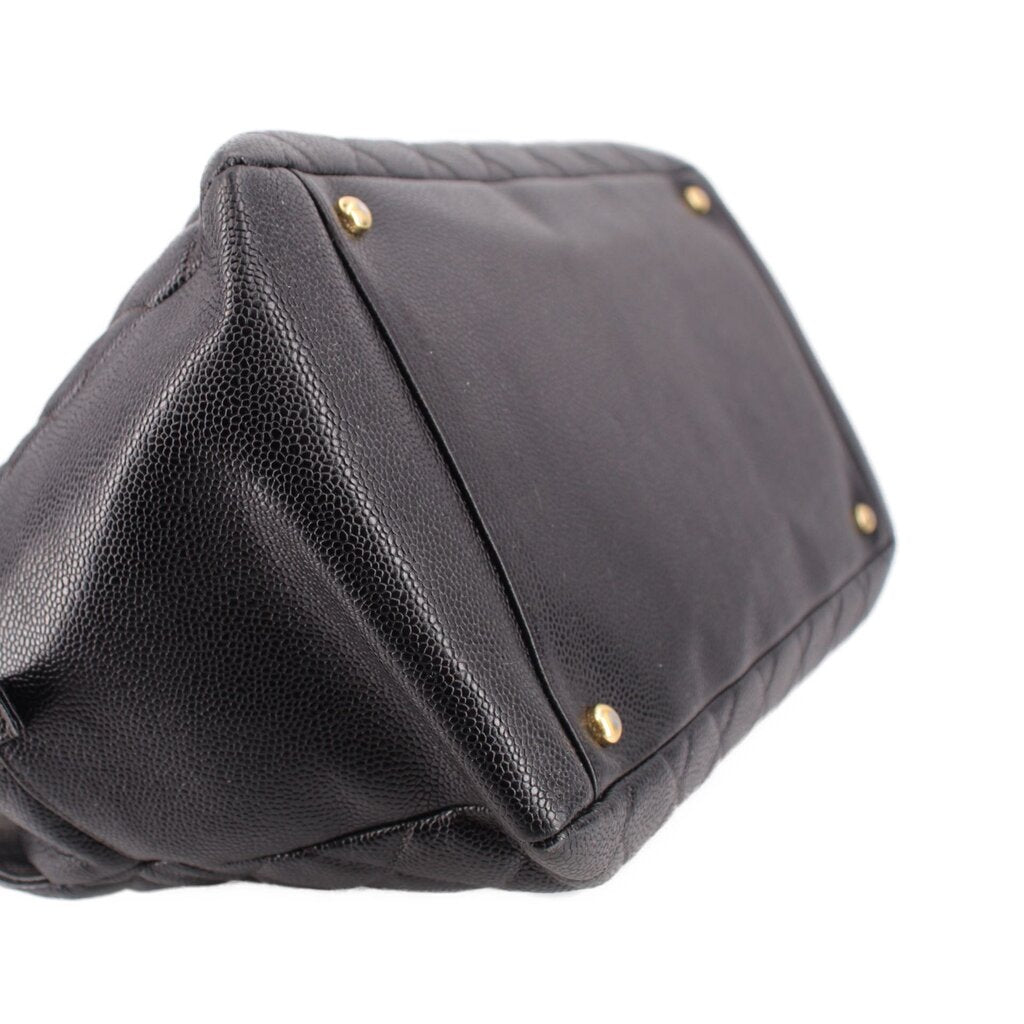 CHANEL grand shopper tote bag angled close-up showing dark leather trim and gold studs