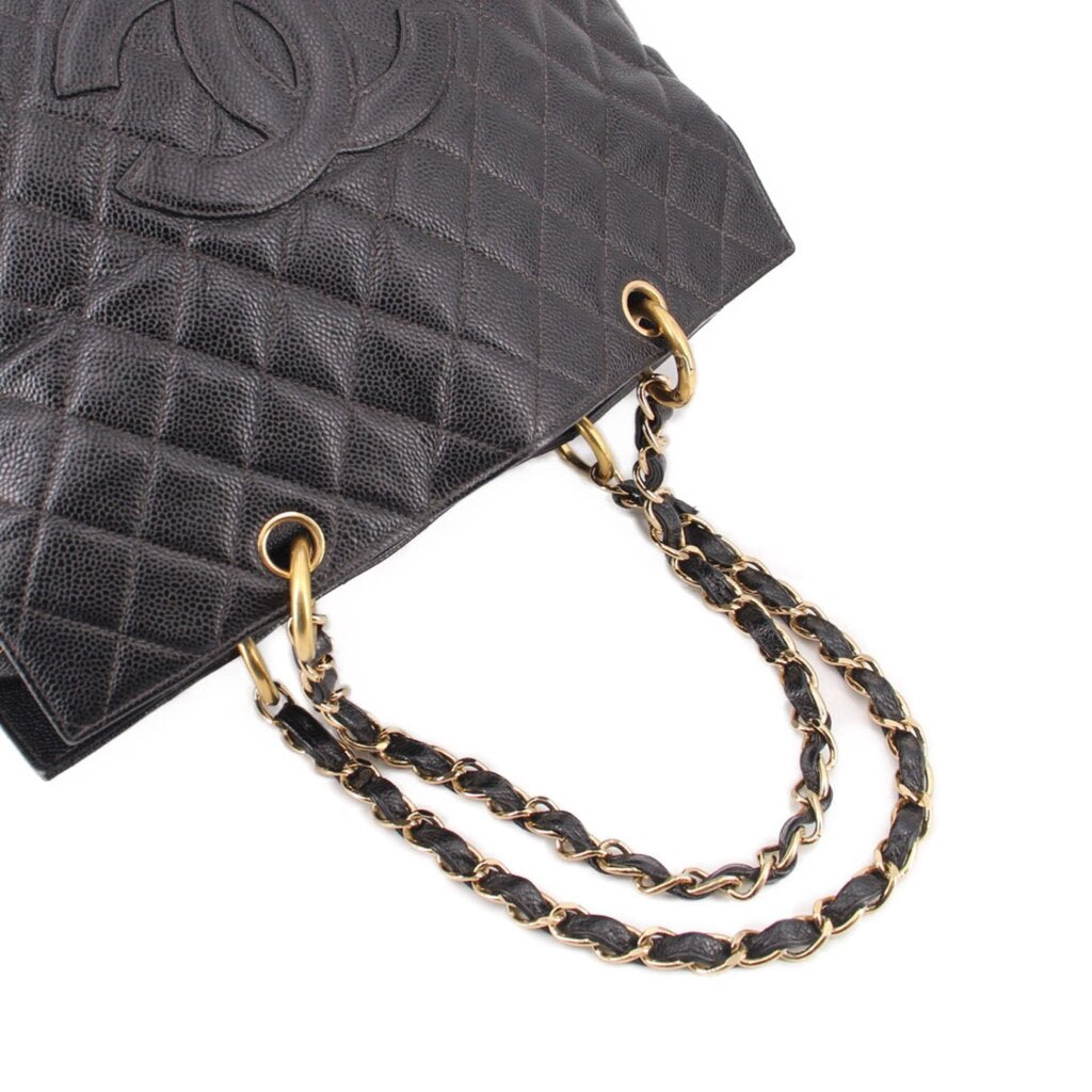 Black quilted leather tote with gold-tone chain handles and metal ring detail