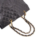 Black quilted leather tote with gold-tone chain handles and metal ring detail