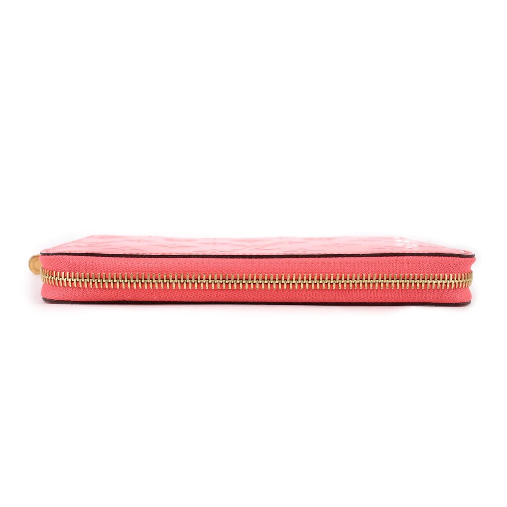 Coral zip wallet with slim profile and gold-tone zipper across top edge