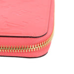 Coral vernis wallet corner with gold-tone zipper and contrast black edge trim