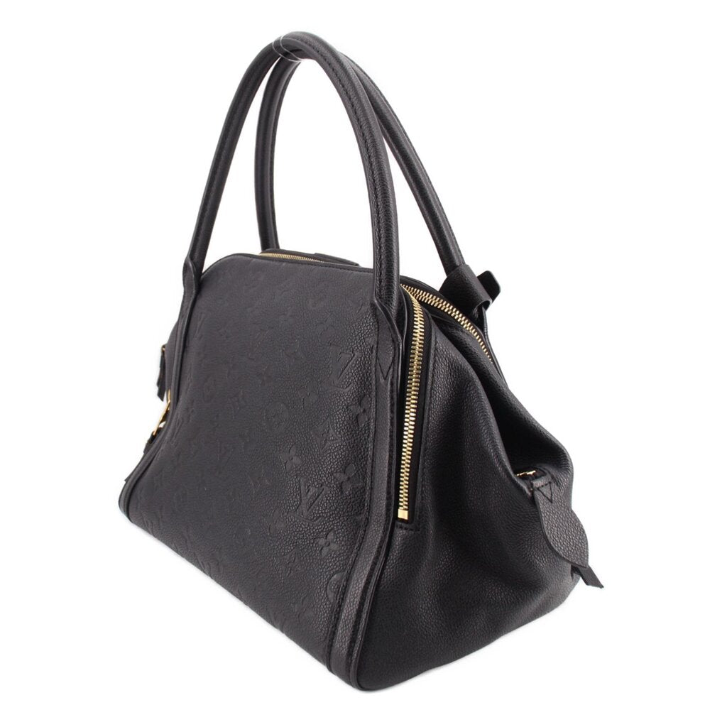 Black monogram handle bag with side zipper and hanging leather tassels with gold ends.