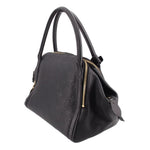 Black monogram handle bag with side zipper and hanging leather tassels with gold ends.