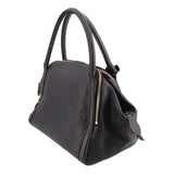 Black monogram handle bag with side zipper and hanging leather tassels with gold ends.