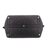Black top-handle bag with centered strap detail, gold rivets, and embossed monogram.
