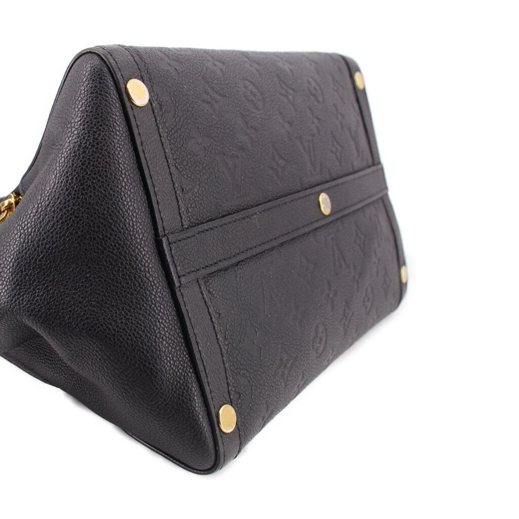 Black leather handle bag close-up of strap panel with gold rivets and monogram embossing.