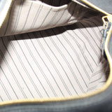 Open bag interior with light striped lining and gold zipper edge visible.