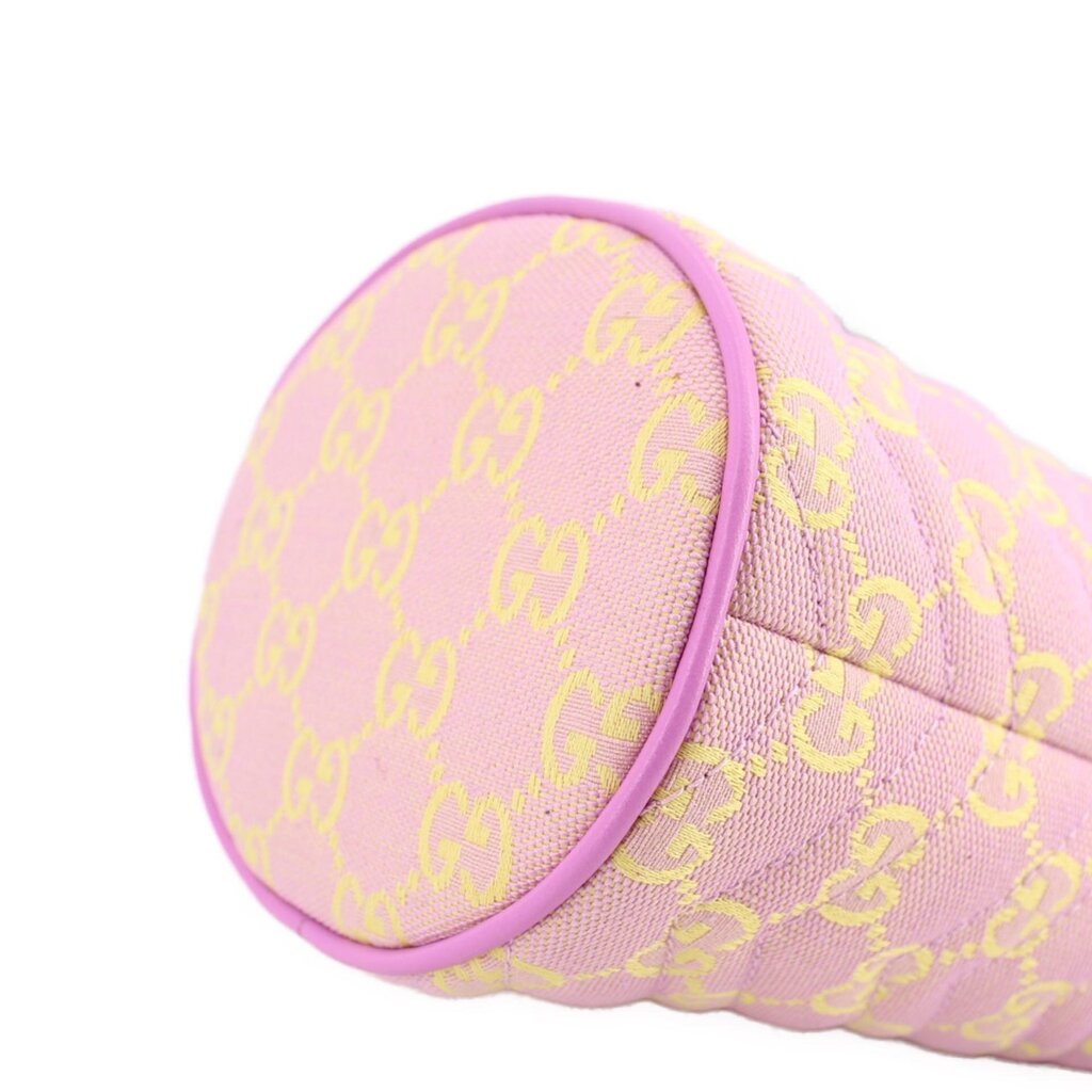 Close view of pink mini bucket crossbody side panel with GG monogram print and piping.
