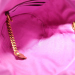 Close-up of pink fabric bucket opening edge with gold-toned chain detail inside.