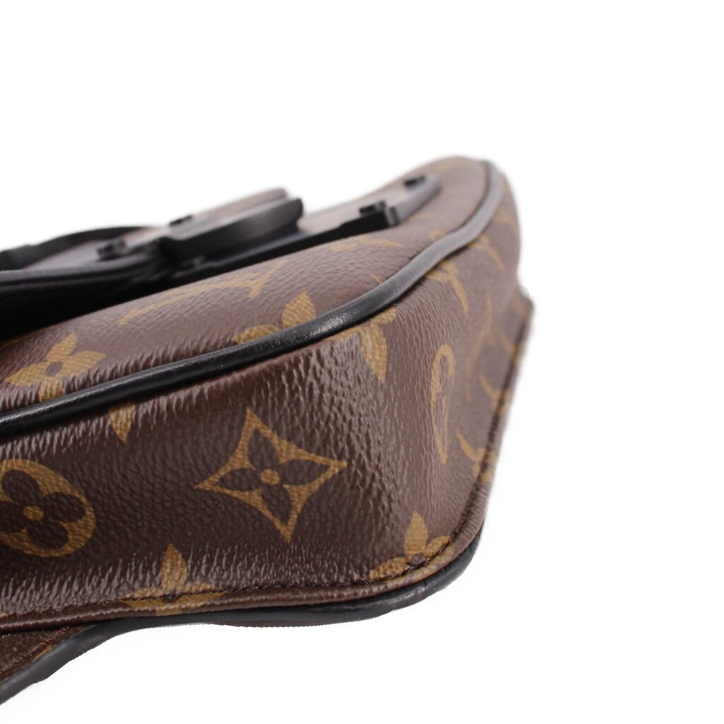 Monogram sling belt bag close-up of brown leather trim and black edge piping
