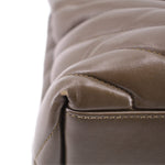 YSL puffer shoulder bag close-up: olive stitched leather seam and edge