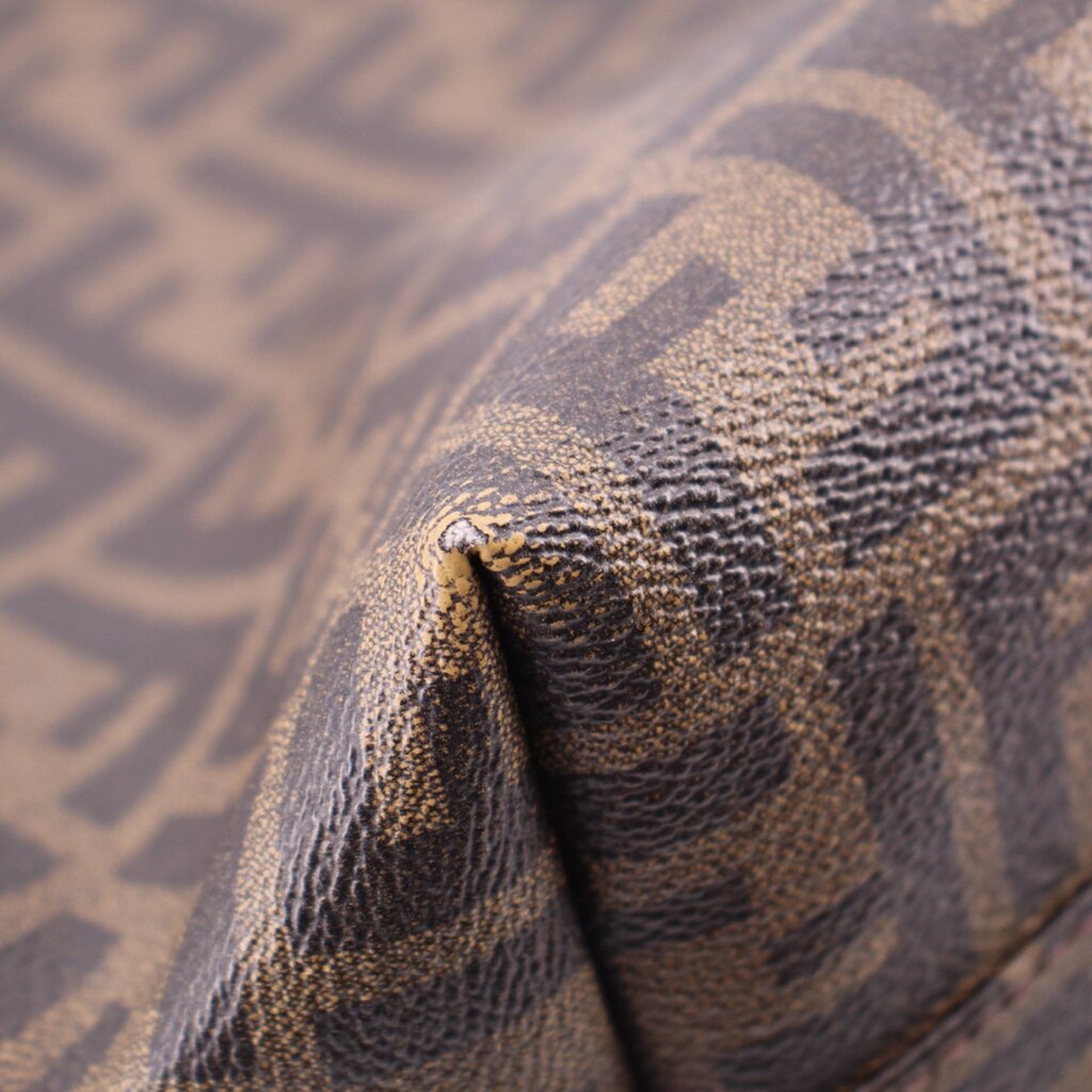 Tobacco Zucca FF monogram canvas edge with brown leather piping close-up.