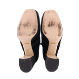Bottom view of black suede ankle boots with flat soles