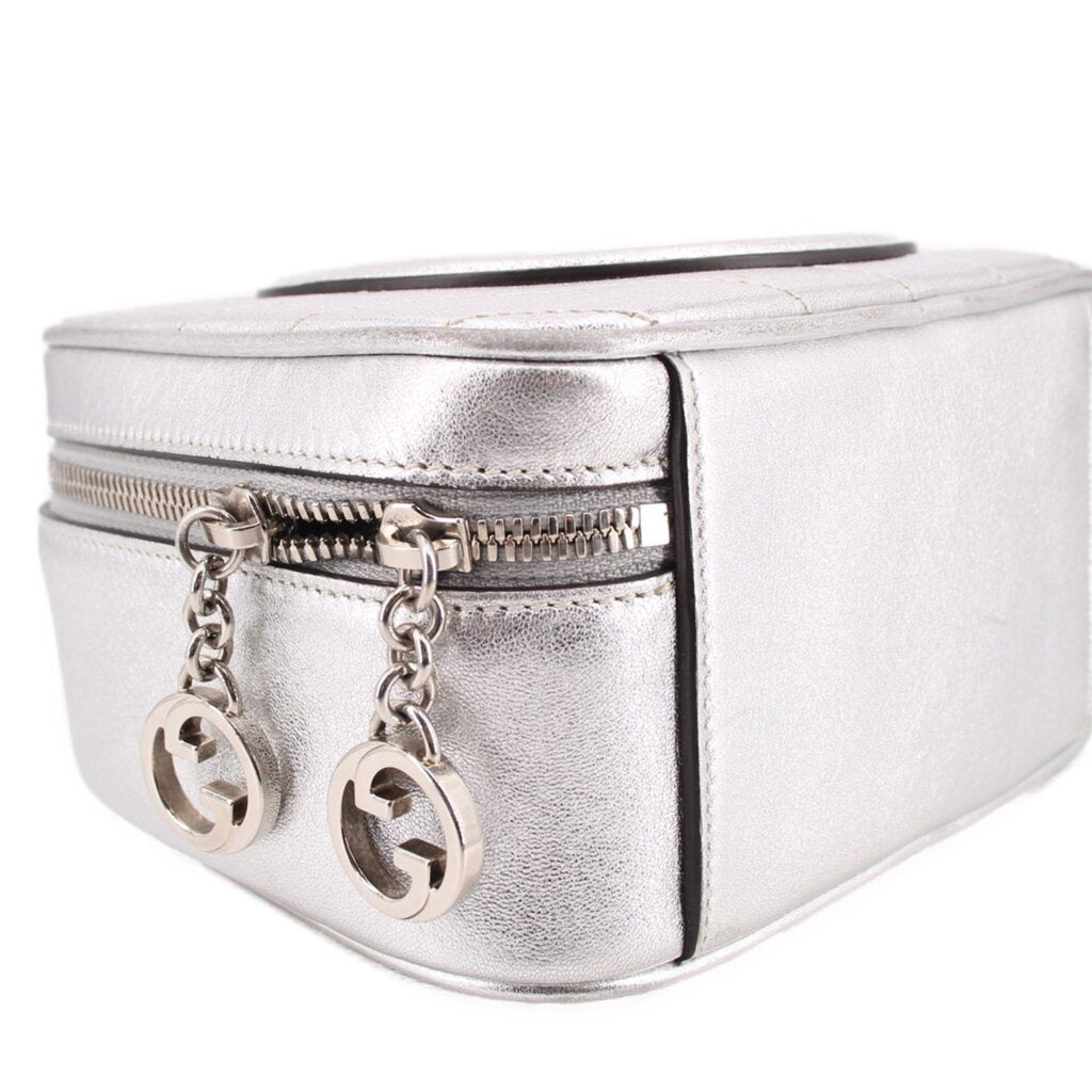Gucci silver mini crossbody bag close-up with double zipper pulls and chain accents