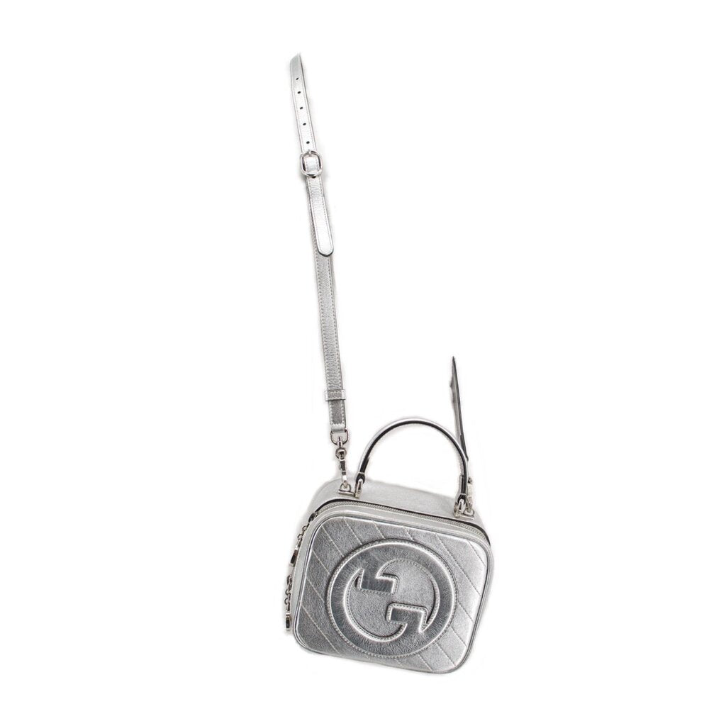 GUCCI Blondie mini top-handle crossbody bag, silver with embossed GG logo and short strap.