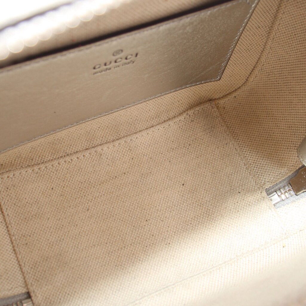 Gucci silver crossbody bag interior with beige lining and stitched logo label