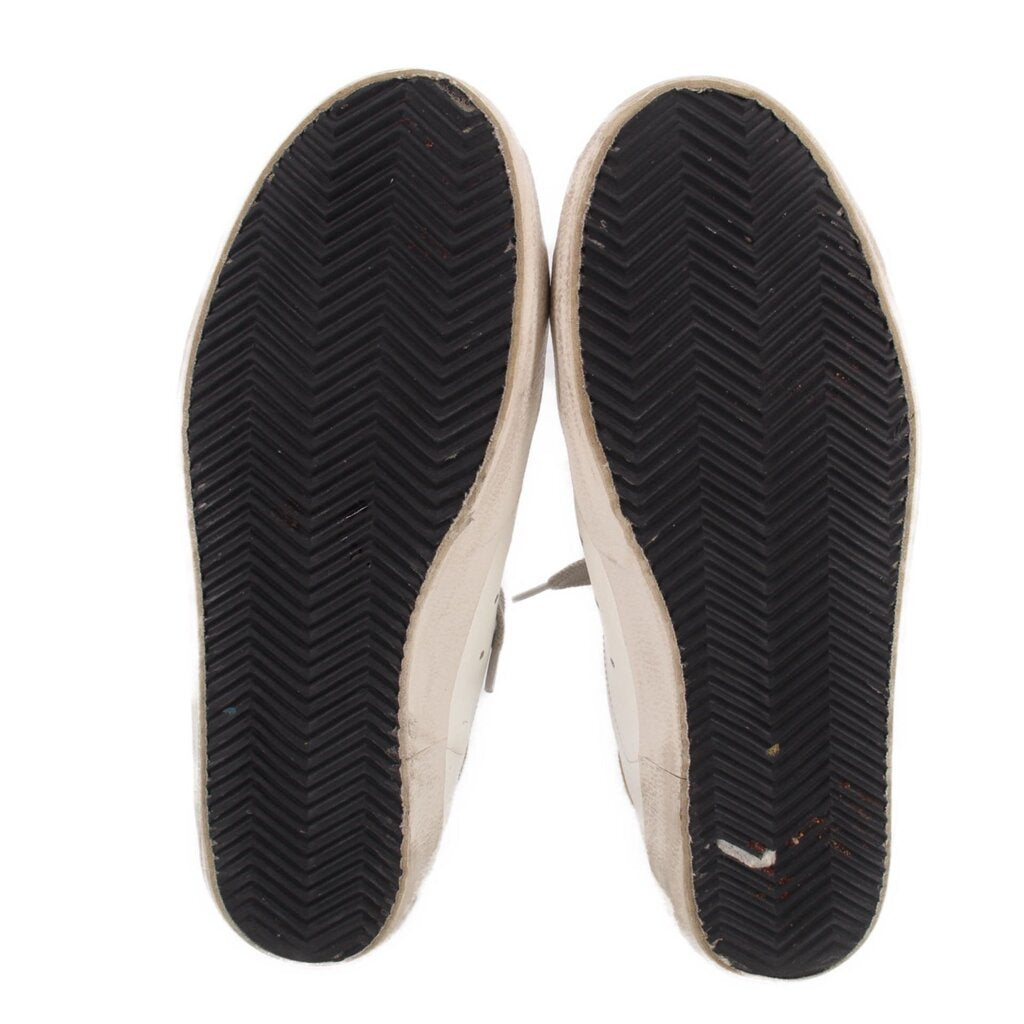 Bottom soles of white mixed leather sneakers with dark tread pattern
