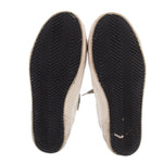 Bottom soles of white mixed leather sneakers with dark tread pattern