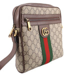 GUCCI crossbody messenger bag side view with GG canvas, brown leather edges, and web stripe