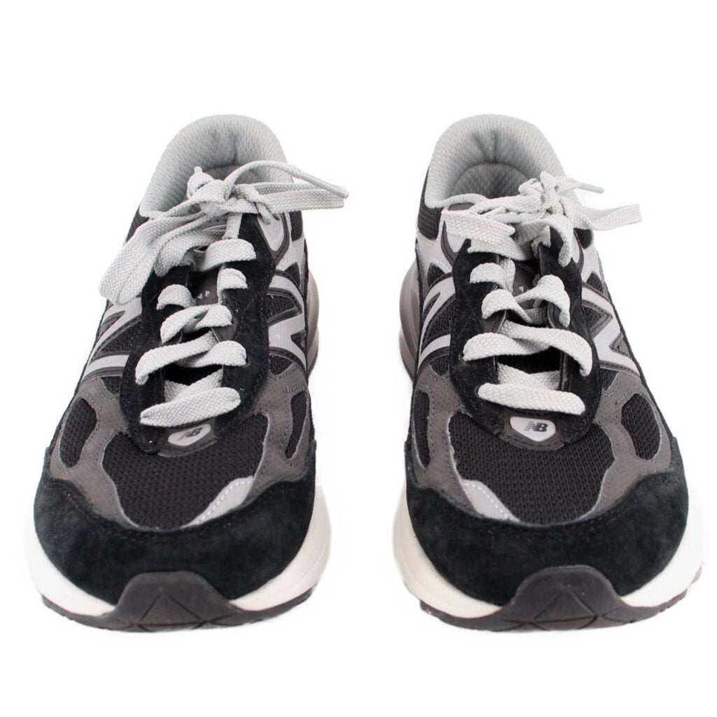 Pair of black and gray New Balance sneakers shown from the front with white laces