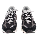 Pair of black and gray New Balance sneakers shown from the front with white laces