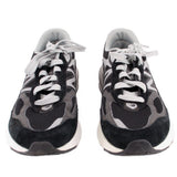 Pair of black and gray New Balance sneakers shown from the front with white laces